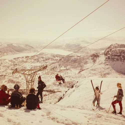 Gammelt foto fra 1969 som viser den første stolheisen, utsikt fra toppen av Storenos og skiturister i tidsriktig skiklær. Foto