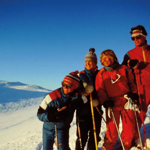 Fire ungdommer på ski nyter sol og utsikt i høyfjellet på Hovden Skisenter.