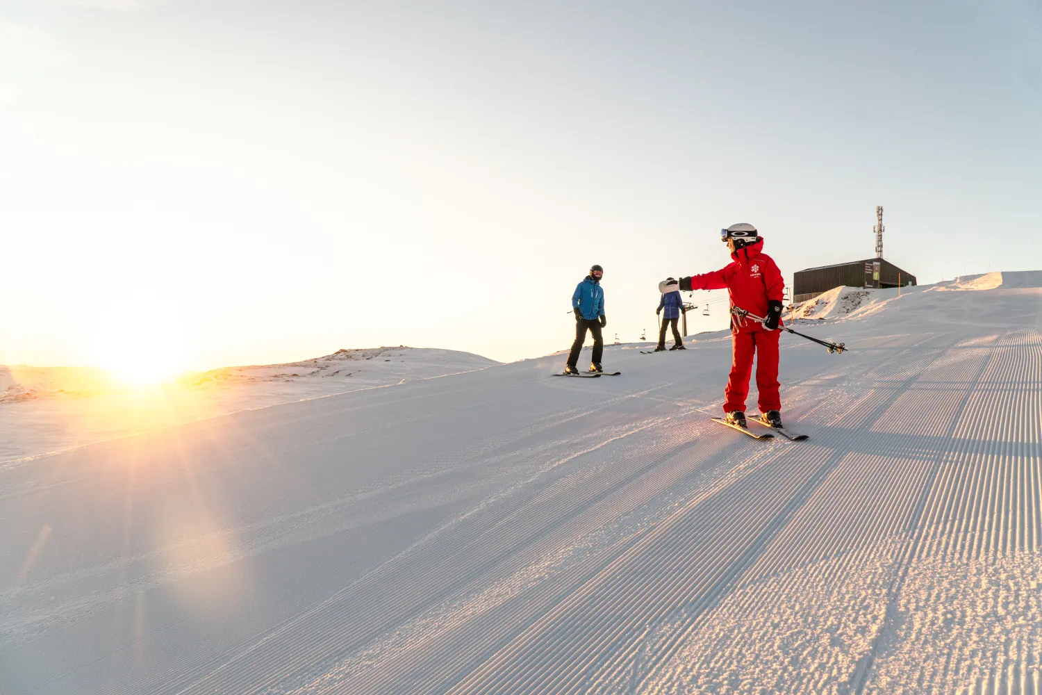 Personlig trener som lærer 2 folk å stå på ski i bakken