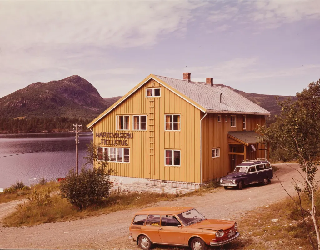 Hartevassbu med en bil og flott utsikt av Hovdenuten i bakgrunnen