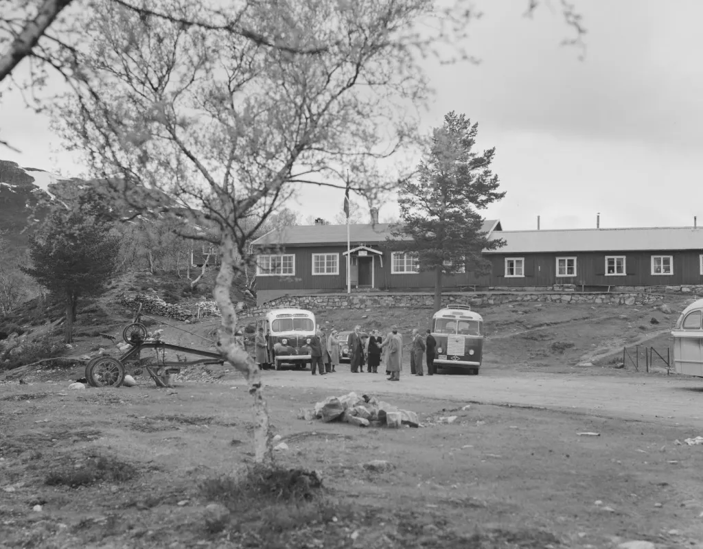 Gammelt bilde av Hovdehytta anno 1953. Busser og biler fra den tiden og folk i tidsriktige klær.