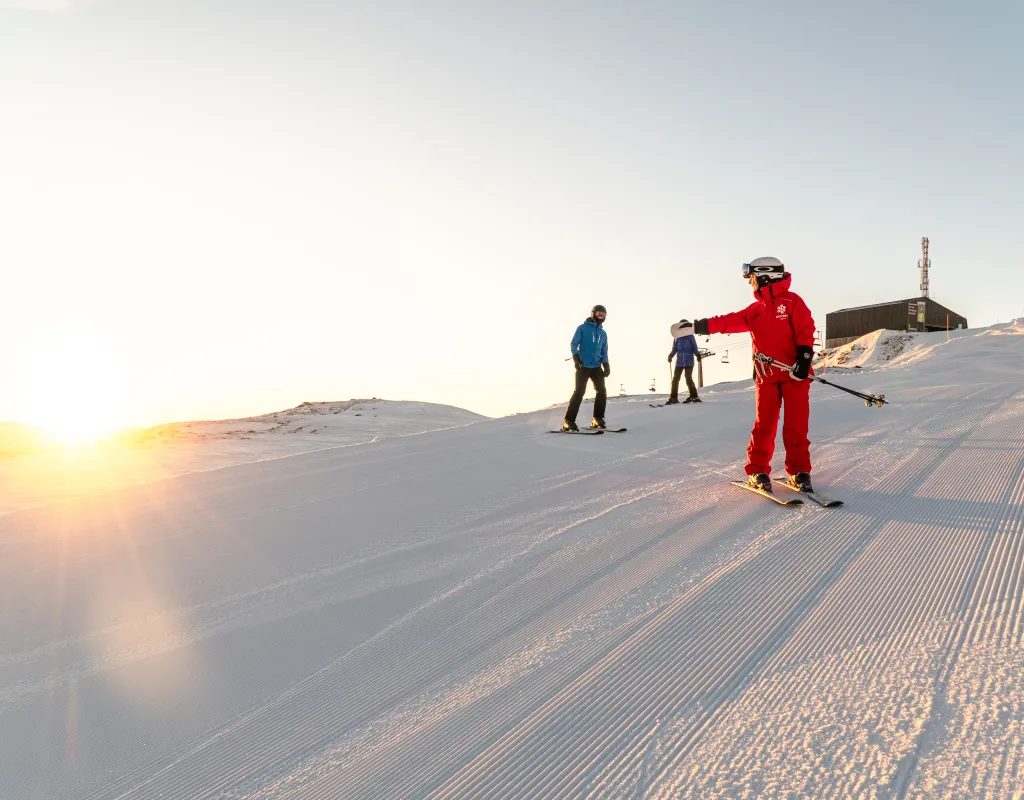 Personlig trener som lærer 2 folk å stå på ski i bakken