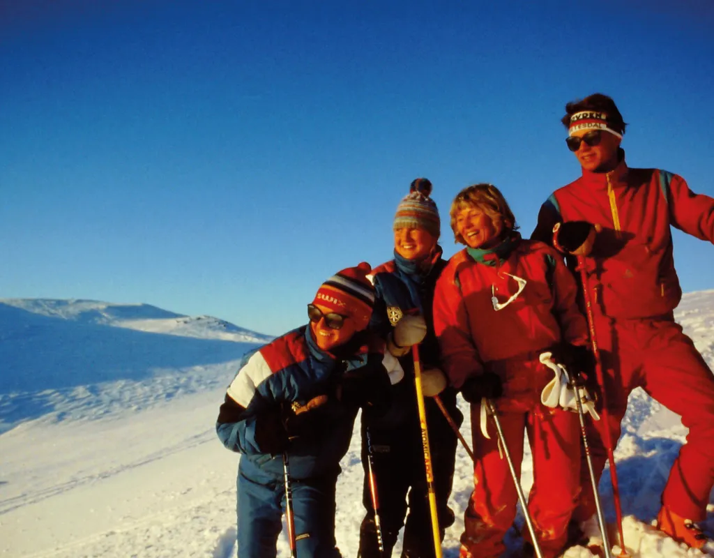 Fire ungdommer på ski nyter sol og utsikt i høyfjellet på Hovden Skisenter.